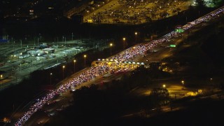 AX121_198E - 5.5K aerial stock footage orbit heavy traffic at a Toll Booth at Night in New Jersey