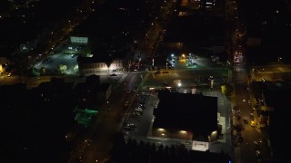 5.5K aerial stock footage approach shops by a city street in Jersey City, New Jersey, at Night Aerial Stock Footage | AX122_004