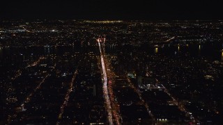 AX122_050E - 5.5K aerial stock footage of heavy traffic on Delancey Street to Williamsburg Bridge at Night, Lower East Side, NYC