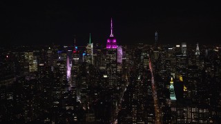 AX122_052E - 5.5K aerial stock footage of a wide orbit of the Empire State Building at Night in Midtown Manhattan, NYC