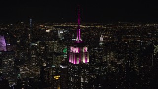 5.5K aerial stock footage orbit the rooftop of Empire State Building as it lights up at Night in Midtown, New York City Aerial Stock Footage | AX122_085E