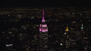 5.5K aerial stock footage circle the Empire State Building with pink and white lights at Night, Midtown, NYC Aerial Stock Footage | AX122_100E