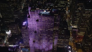 AX122_136E - 5.5K aerial stock footage approach Rockefeller Center at Night in Midtown, New York City