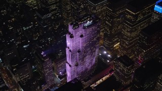 AX122_199E - 5.5K aerial stock footage of an orbit of Rockefeller Center at Night in Midtown Manhattan, New York City