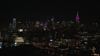 5.5K aerial stock footage of tall Midtown Manhattan Skyscrapers seen from riverfront buildings in Chelsea at Night, NYC Aerial Stock Footage | AX122_292E