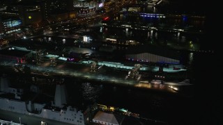 AX123_002E - 5.5K aerial stock footage approach USS Intrepid in Hell's Kitchen at Night in Midtown, New York City