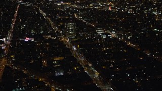 AX123_024E - 5.5K aerial stock footage orbit city streets and office buildings in Harlem at Night in New York City