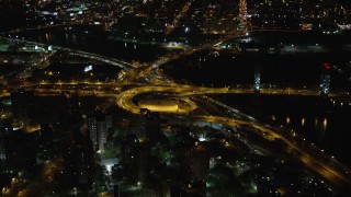 AX123_031 - 5.5K aerial stock footage of riverfront freeway interchange by Robert F. Kennedy Bridge at Night, Harlem, New York City