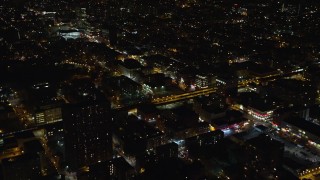 5.5K aerial stock footage fly over apartment buildings by elevated rail tracks at Night in Harlem, New York City Aerial Stock Footage | AX123_032