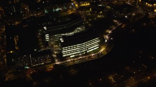 AX123_043E - 5.5K aerial stock footage approach a modern Harlem office building at Night in NYC