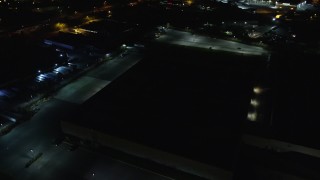 5.5K aerial stock footage approach dark warehouse at Night in Farmingdale, New York Aerial Stock Footage | AX123_189E