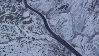 5.5K aerial stock footage of a snowy mountain highway through Wasatch Range at Sunrise in Utah Aerial Stock Footage | AX124_026E