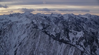 5.5K aerial stock footage approach snowy Wasatch Range mountains in winter at sunrise, Utah Aerial Stock Footage | AX124_054