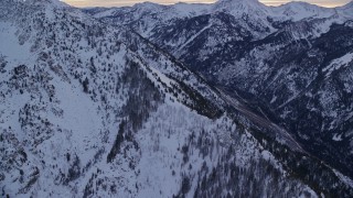 5.5K aerial stock footage orbit mountain slopes with winter snow in Wasatch Range at sunrise in Utah Aerial Stock Footage | AX124_064