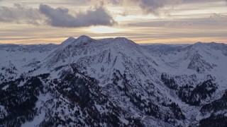 5.5K aerial stock footage of a snowy peak in winter at sunrise in Wasatch Range, Utah Aerial Stock Footage | AX124_068E