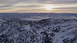 5.5K aerial stock footage of the sunrise seen while orbiting Wasatch Range snow mountains in Utah Aerial Stock Footage | AX124_077E