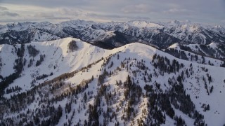 5.5K aerial stock footage a snowy Wasatch Range ridge in winter at sunrise, Utah Aerial Stock Footage | AX124_099E