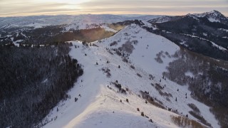 5.5K aerial stock footage approach snowdrifts blowing off of mountains in the Wasatch Range, Utah at sunrise Aerial Stock Footage | AX124_108E