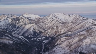 5.5K aerial stock footage of Wasatch Range mountains in wintertime with snow at sunrise, Utah Aerial Stock Footage | AX124_133E