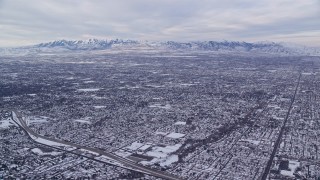 5.5K aerial stock footage of Salt Lake City suburbs and Oquirrh Mountains in winter snow at sunrise, Utah Aerial Stock Footage | AX124_178E