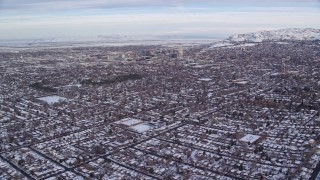 5.5K aerial stock footage fly over suburban homes with snow toward Downtown Salt Lake City at sunrise in Utah Aerial Stock Footage | AX124_189E