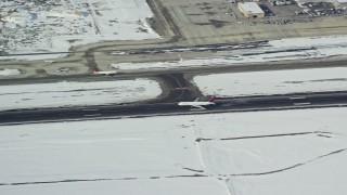 5.5K aerial stock footage track airliner landing at Salt Lake City International Airport with winter snow in Utah Aerial Stock Footage | AX125_011E