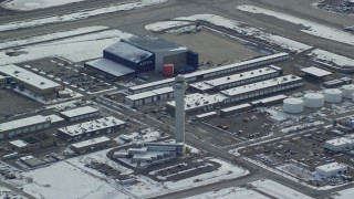 5.5K aerial stock footage of a reverse view of control tower at Salt Lake City International Airport in winter, Utah Aerial Stock Footage | AX125_017