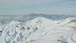 5.5K aerial stock footage of snowy mountain summits on Antelope Island in winter, Utah Aerial Stock Footage | AX125_035E