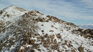 5.5K aerial stock footage orbiting rocky slopes of a peak in winter with snow on Utah's Antelope Island Aerial Stock Footage | AX125_063