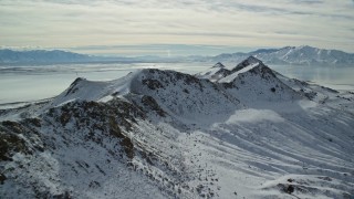 5.5K aerial stock footage approach and fly over a snowy mountain ridge on Antelope Island, Utah Aerial Stock Footage | AX125_093E