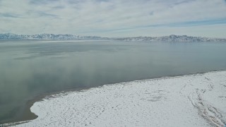 5.5K aerial stock footage of Great Salt Lake with patches of ice seen from Antelope Island in winter, Utah Aerial Stock Footage | AX125_100E