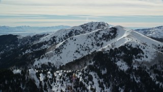 AX125_140 - 5.5K aerial stock footage of a pair of snowy peaks in the Oquirrh Mountains of Utah