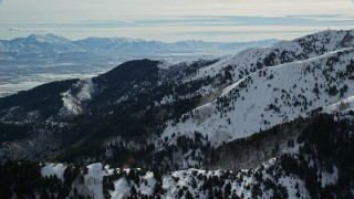 5.5K aerial stock footage of snow mountains and trees in winter in Oquirrh Mountains, Utah Aerial Stock Footage | AX125_141