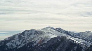 5.5K aerial stock footage of snowdrifts blowing off Oquirrh Mountains peaks in winter, Utah Aerial Stock Footage | AX125_178E