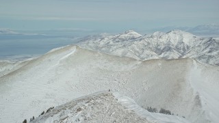 5.5K aerial stock footage fly over one Oquirrh Mountains ridge to approach second ridge in winter, Utah Aerial Stock Footage | AX125_217E