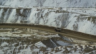 5.5K aerial stock footage of tracking a gravel hauler at the Bingham Canyon Mine in snowy Utah Aerial Stock Footage | AX125_241