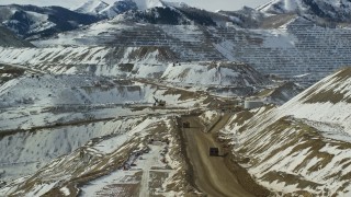 5.5K aerial stock footage track gravel haulers at the Bingham Canyon Copper Mine with winter snow in Utah Aerial Stock Footage | AX125_242E