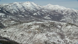 5.5K aerial stock footage orbit round-topped mountain with light winter snow, Oquirrh Mountains, Utah Aerial Stock Footage | AX125_280