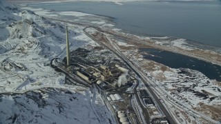 5.5K aerial stock footage of Kennecott Smokestack and factory buildings with winter snow in Magna, Utah Aerial Stock Footage | AX125_295E