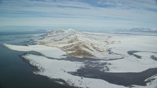 5.5K aerial stock footage approach snowy mountains on the shore of Antelope Island, Utah Aerial Stock Footage | AX125_311E