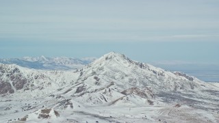 5.5K aerial stock footage of orbiting a snowy Antelope Island mountain peak in winter, Utah Aerial Stock Footage | AX125_315