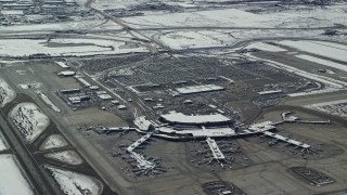 5.5K aerial stock footage orbit terminals and parking lot at Salt Lake City Airport with winter snow, Utah Aerial Stock Footage | AX125_332