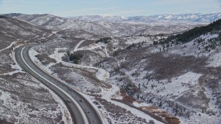 5.5K aerial stock footage fly over freeway with light traffic through wintery mountain pass with snow, Wasatch Range, Utah Aerial Stock Footage | AX126_084E