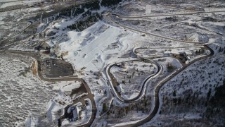 5.5K aerial stock footage circle above the luge and bobsled track at Utah Olympic Park in winter, Park City Aerial Stock Footage | AX126_105