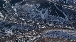 5.5K aerial stock footage orbit small town in winter shaded by snowy mountain, Park City, Utah Aerial Stock Footage | AX126_150