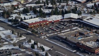 AX126_163 - 5.5K aerial stock footage orbit small town strip mall with winter snow in Park City, Utah