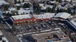 5.5K aerial stock footage of orbiting shops at a small town strip mall with winter snow in Park City, Utah Aerial Stock Footage | AX126_164