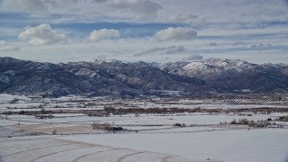 5.5K aerial stock footage of small town at the base of snowy mountain range in winter, Heber City, Utah Aerial Stock Footage | AX126_218E