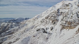 5.5K aerial stock footage of snow covered slopes of Mount Timpanogos in wintertime, Utah Aerial Stock Footage | AX126_257E