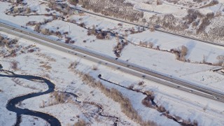 5.5K aerial stock footage of light traffic on highway through snowy countryside in winter, Heber City, Utah Aerial Stock Footage | AX127_009E